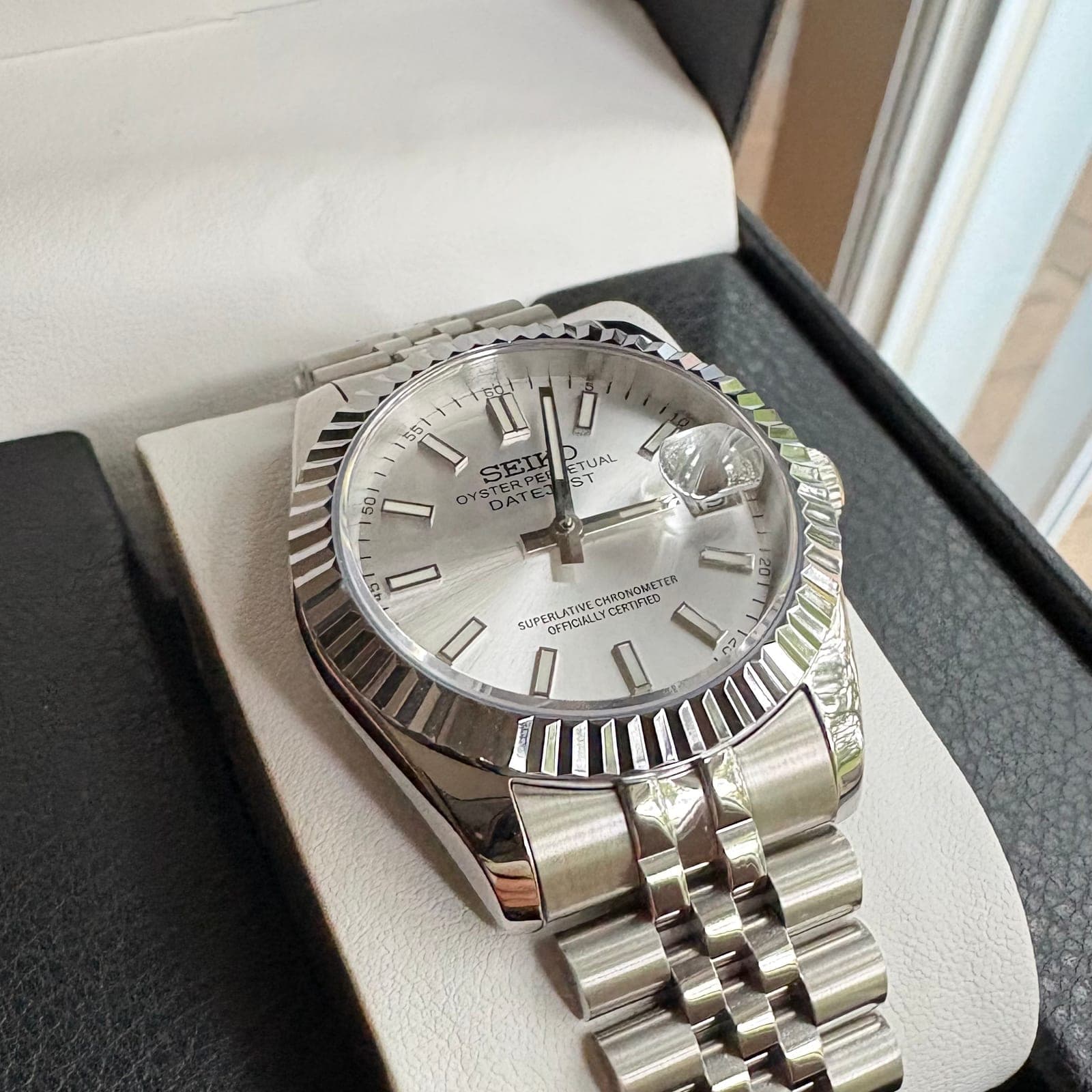 The finished 003SC in its box: silver sunburst dial, fluted steel bezel, jubilee bracelet